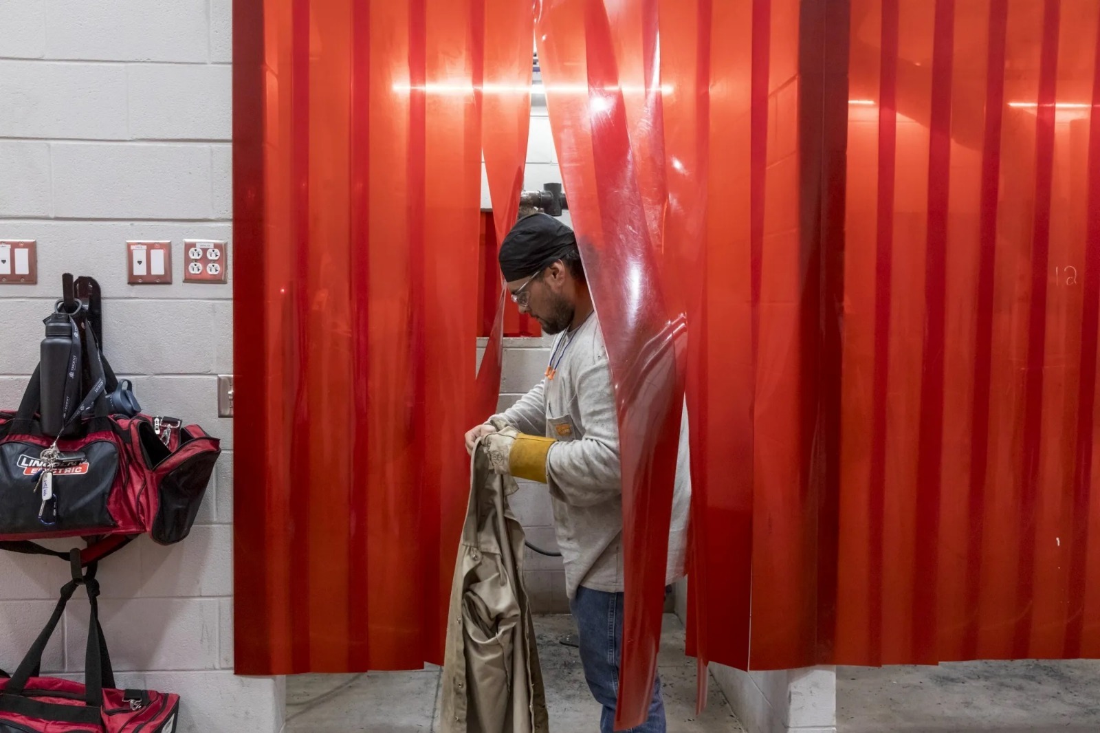 طالب في برنامج التدريب السريع في التصنيع الدفاعي يرتدي معدات الحماية قبل دخوله إلى حجرة اللحام - بلومبرغ طالب في برنامج التدريب السريع في التصنيع الدفاعي يرتدي معدات الحماية قبل دخوله إلى حجرة اللحام - بلومبرغ